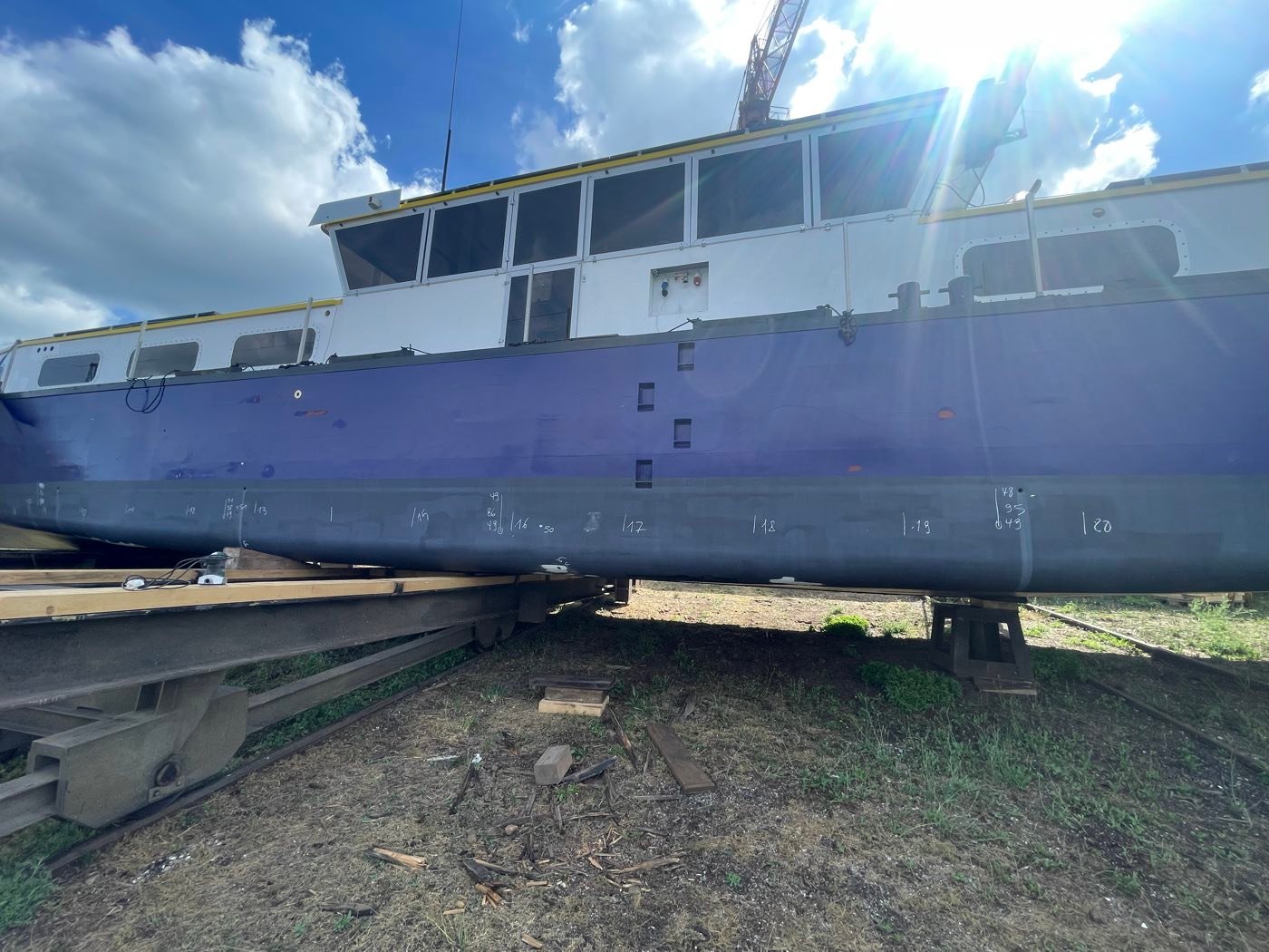 Inspection rapprochée de la coque d'un bateau en cale sèche, repères de mesure